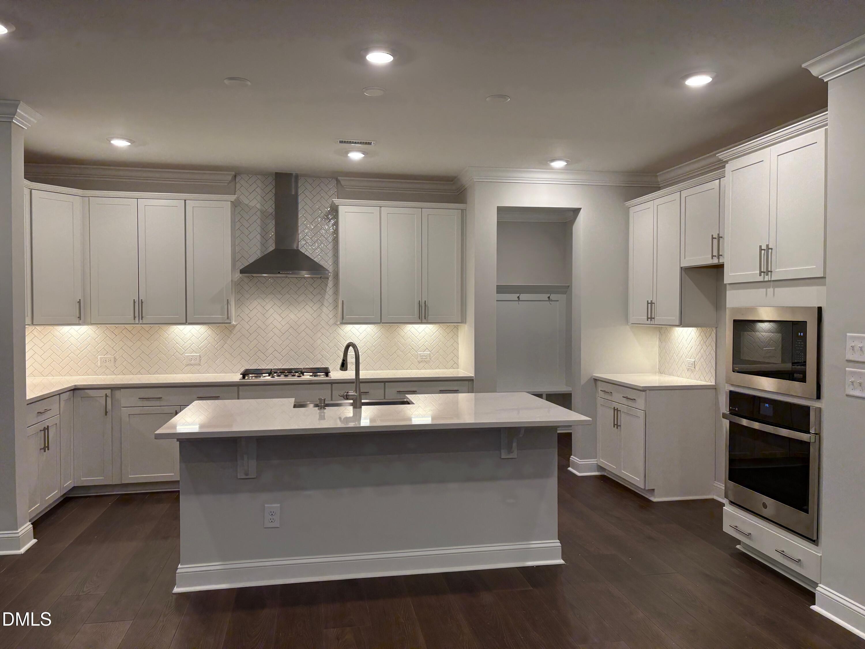 104 Corapeake Way Apex, NC 27539 - Photo 2 of 27 a kitchen with kitchen island granite countertop a stove and a sink