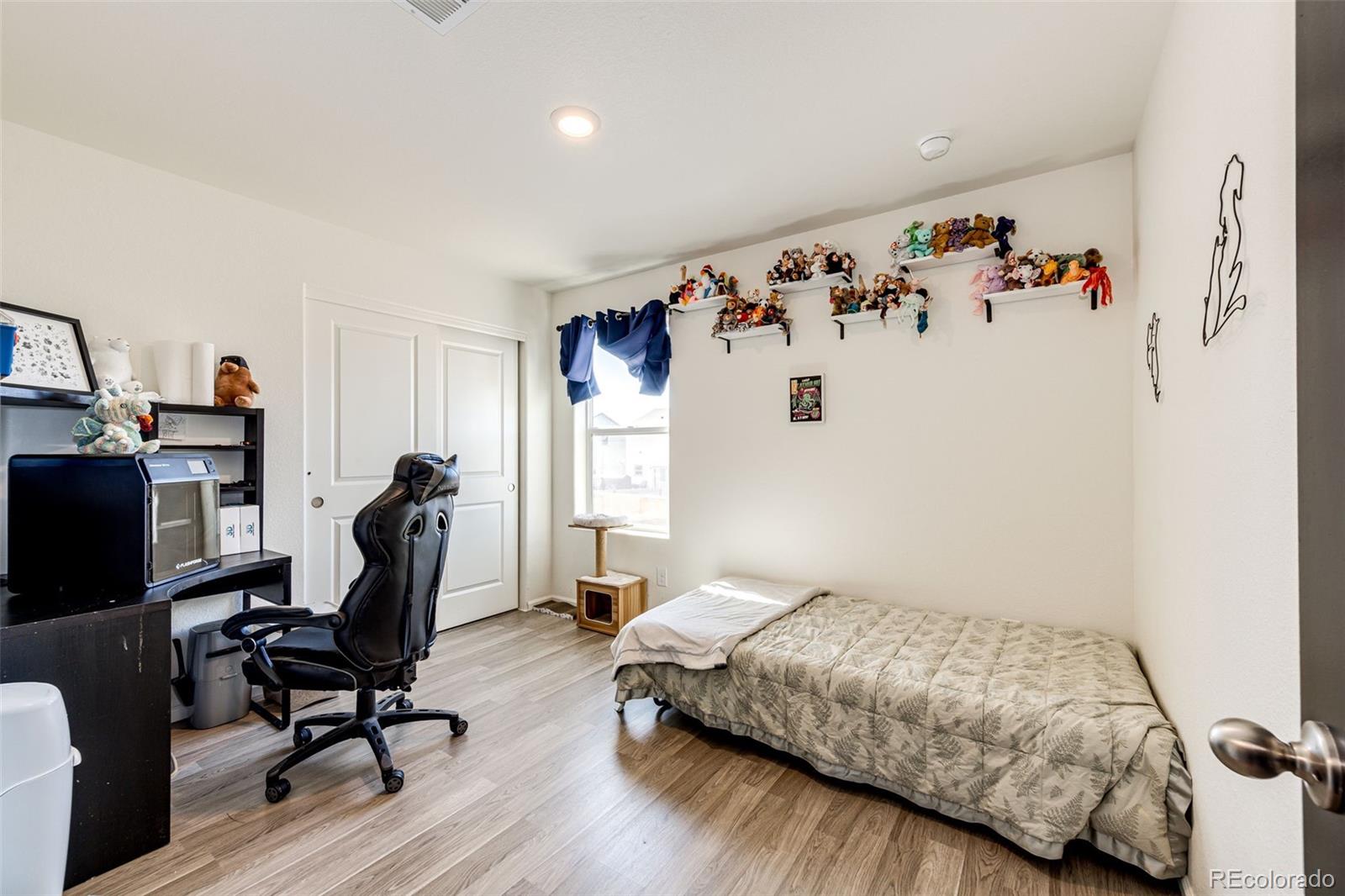 325 Walnut Street Bennett, CO 80102 - Photo 12 of 22 a bedroom with a bed and a chair