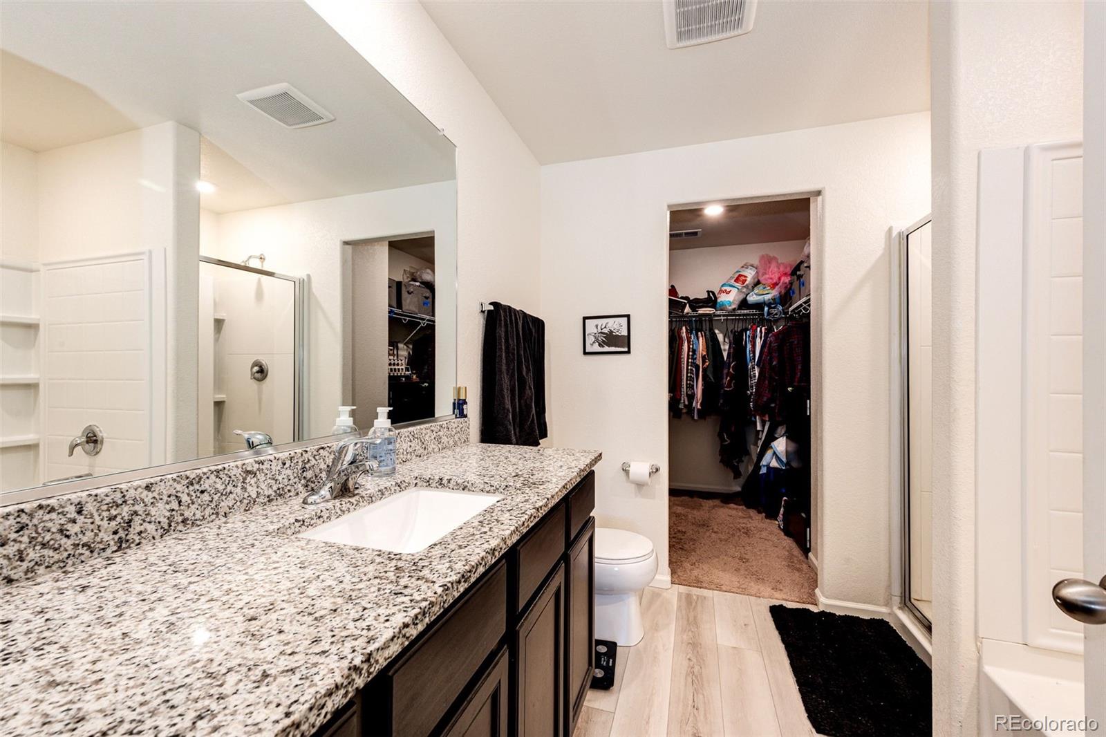 325 Walnut Street Bennett, CO 80102 - Photo 17 of 22 a bathroom with a granite countertop sink a mirror and shower