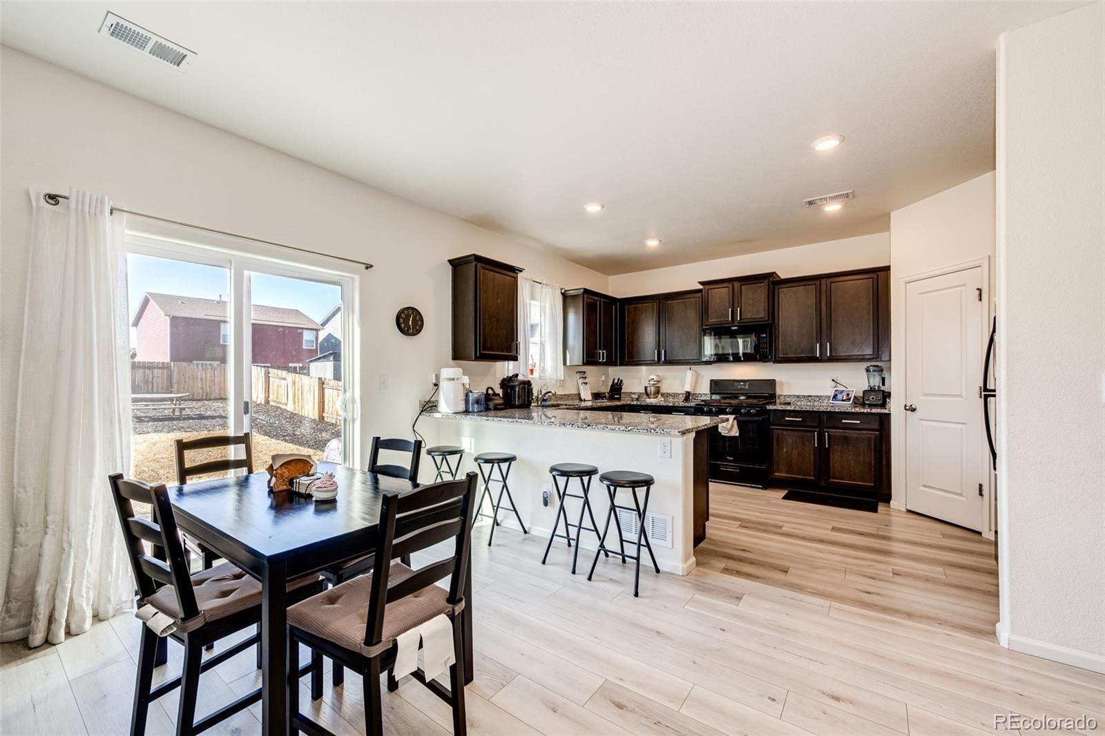 325 Walnut Street Bennett, CO 80102 - Photo 8 of 22 a kitchen with a table and chairs in it