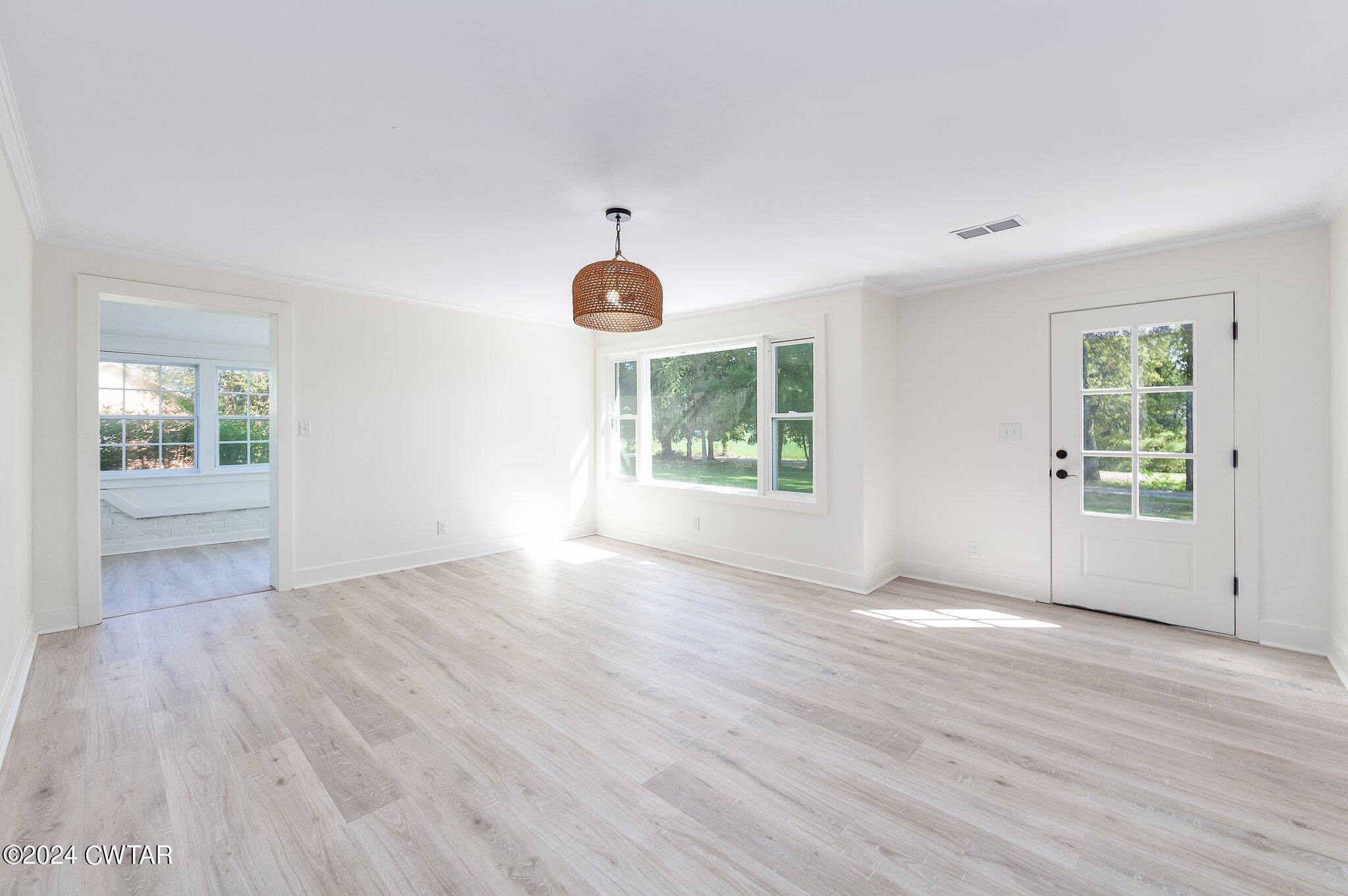 1396 Old Bells Road Jackson, TN 38305 - Photo 4 of 26 an empty room with wooden floor and windows