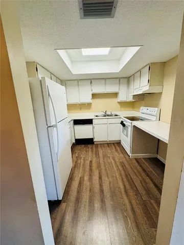 a kitchen with a sink and wooden floor
