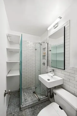 a bathroom with a sink mirror and a toilet