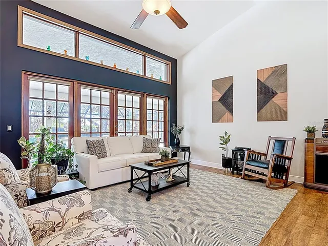 a living room with furniture a flat screen tv and a table