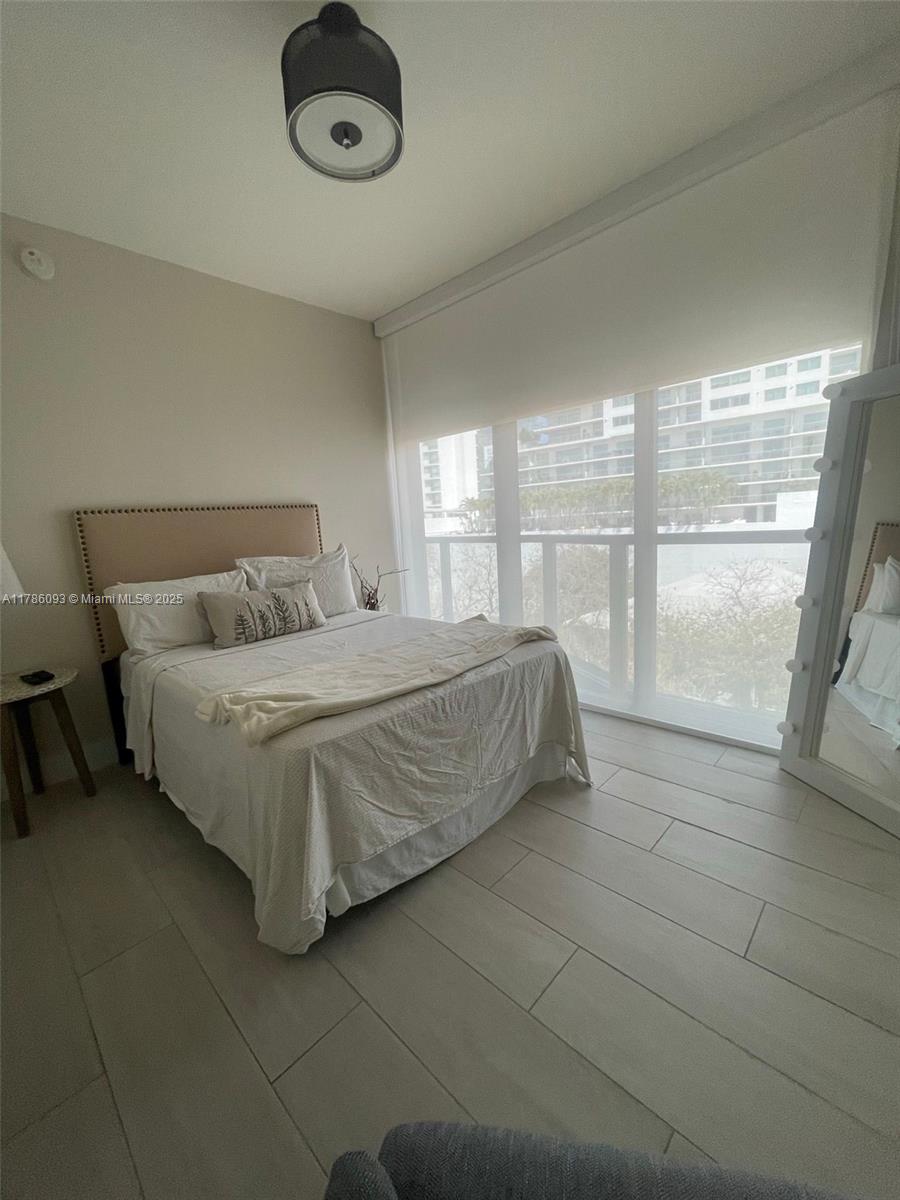 201 Southwest 17th Road, Unit 607 Miami, FL 33129 - Photo 12 of 31 a bedroom with a bed and glass door