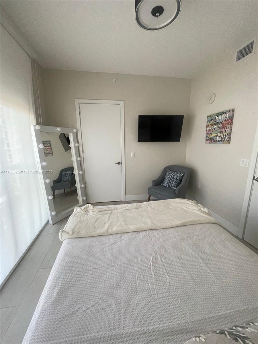 201 Southwest 17th Road, Unit 607 Miami, FL 33129 - Photo 13 of 31 a bedroom with a large bed and a window
