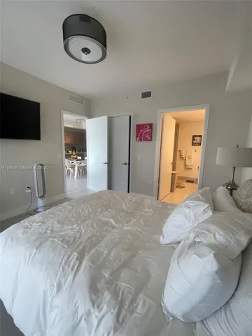a bedroom with a bed and a flat screen tv