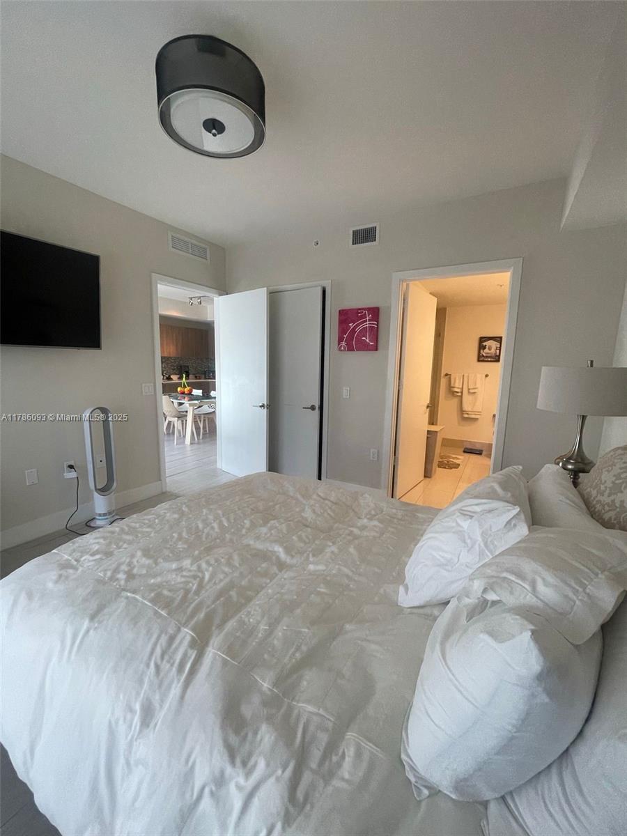 201 Southwest 17th Road, Unit 607 Miami, FL 33129 - Photo 7 of 31 a bedroom with a bed and a flat screen tv