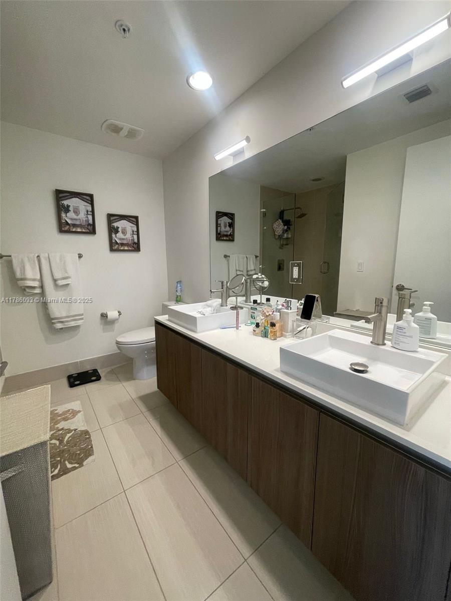 201 Southwest 17th Road, Unit 607 Miami, FL 33129 - Photo 8 of 31 a en suite bathroom with a double vanity sink and a mirror