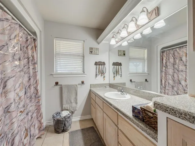 a spacious bathroom with a granite countertop sink and a mirror