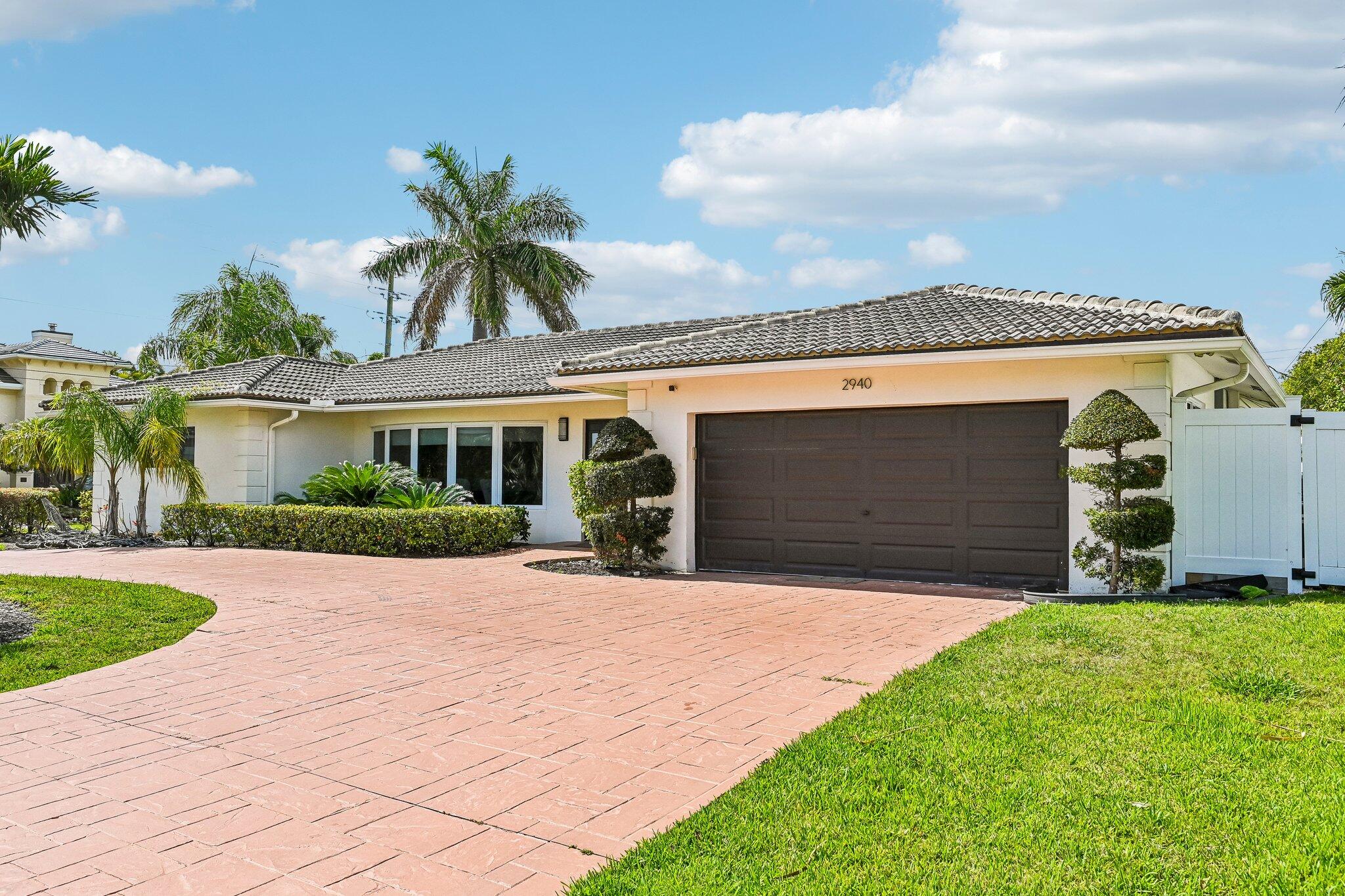 2940 Northeast 39th Court Lighthouse Point, FL 33064 - Photo 37 of 42 a front view of a house with a yard and garage