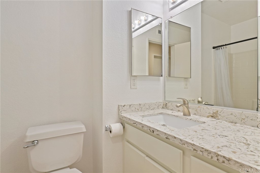 27002 Lightfoot Drive Corona, CA 92883 - Photo 19 of 31 a bathroom with a granite countertop sink a toilet and a mirror