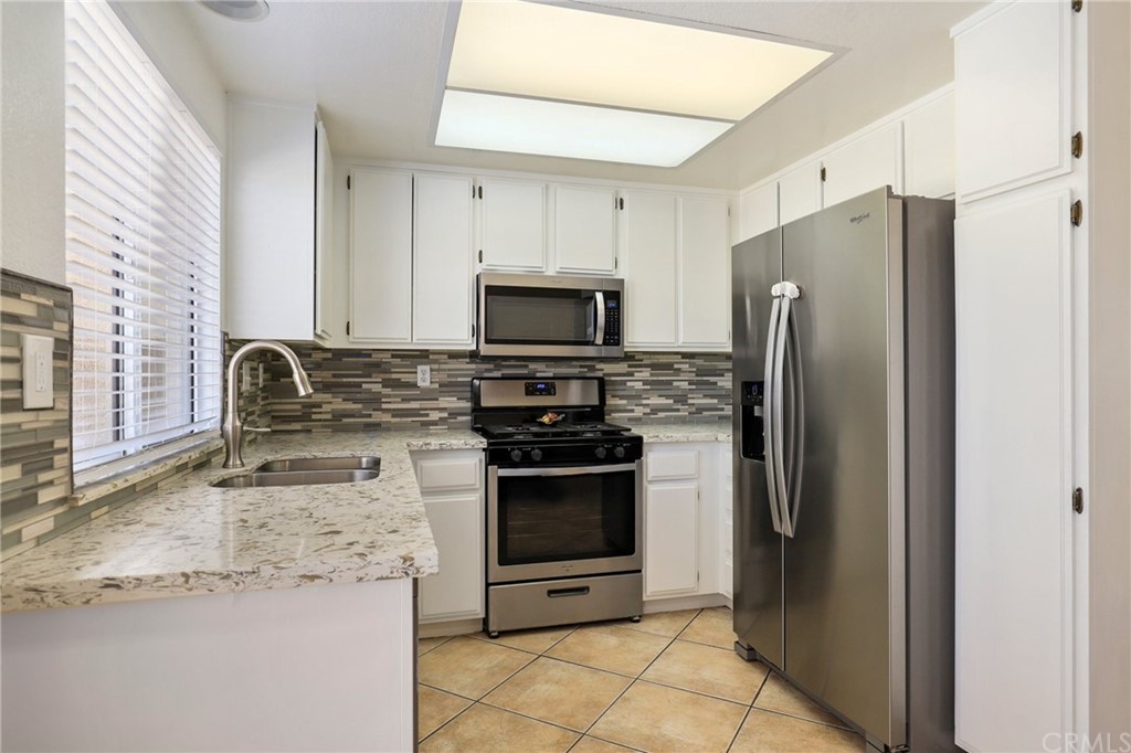 27002 Lightfoot Drive Corona, CA 92883 - Photo 6 of 31 a kitchen with granite countertop a refrigerator and a sink