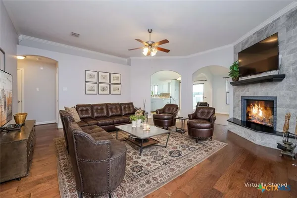a living room with furniture a flat screen tv and a fireplace