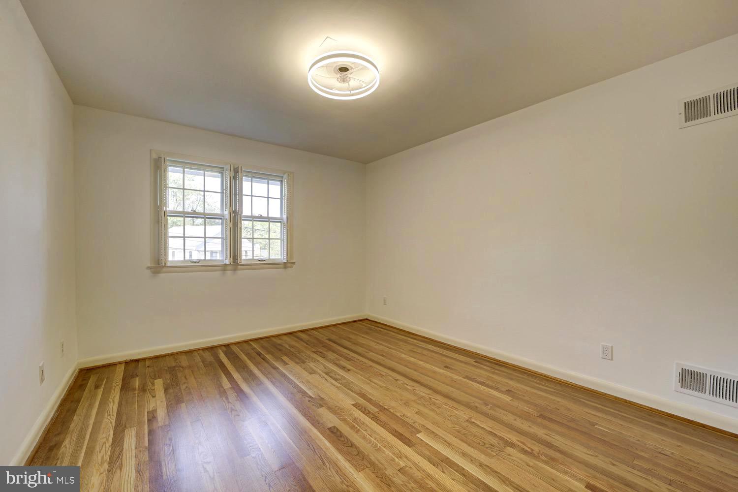 2824 Ellicott Street Northwest Washington, DC 20008 - Photo 38 of 47 an empty room with wooden floor and windows