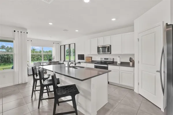 a kitchen with a sink stainless steel appliances and white cabinets