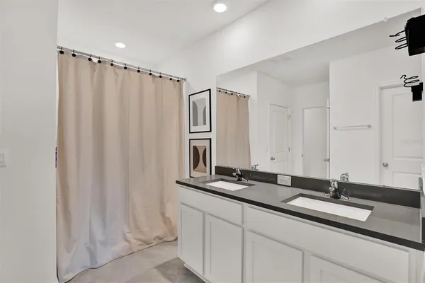 a bedroom with a bed a flat screen tv and a window