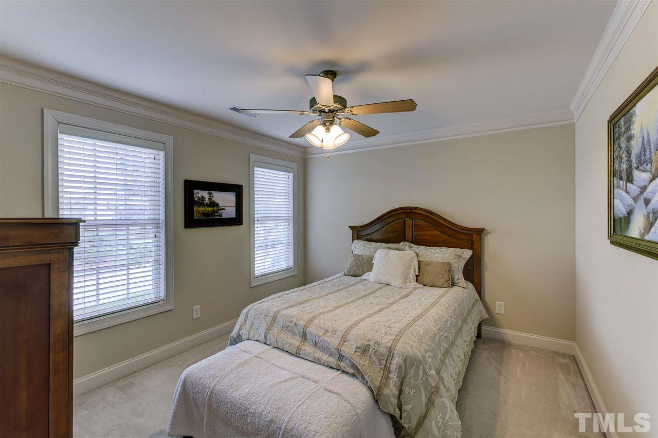 5804 Turner Store Lane Raleigh, NC 27603 - Photo 20 of 25 a bedroom with a bed and a chandelier