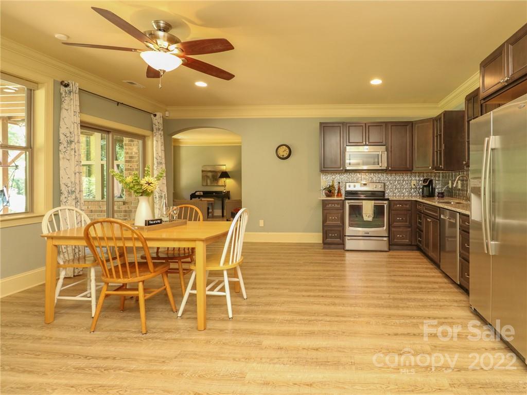 251 Old Post Road Weddington, NC 28173 - Photo 29 of 46 a view of a kitchen with kitchen island granite countertop wooden floor cabinets and stainless steel appliances
