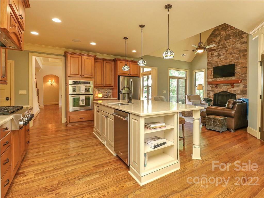 251 Old Post Road Weddington, NC 28173 - Photo 8 of 46 a large kitchen with stainless steel appliances kitchen island granite countertop a large kitchen island a stove a refrigerator a sink and a dining table with wooden floor