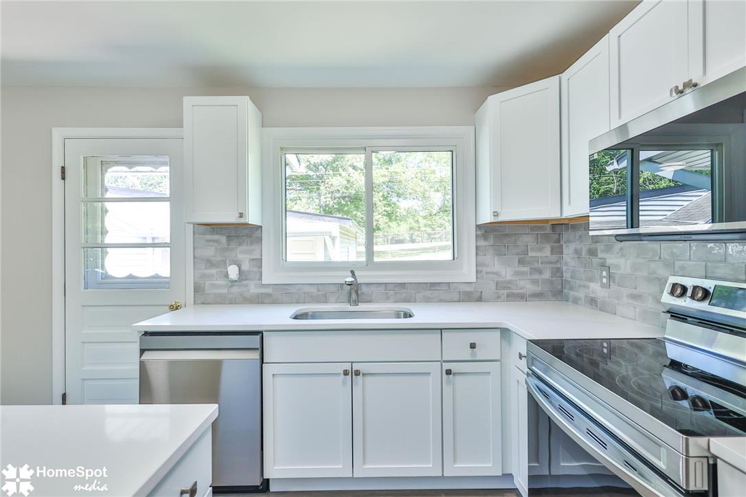 415 Willow Road Hellertown, PA 18055 - Photo 14 of 25 A well-lit kitchen with sleek countertops and ample cabinetry, offering an inviting space for culinary endeavors.