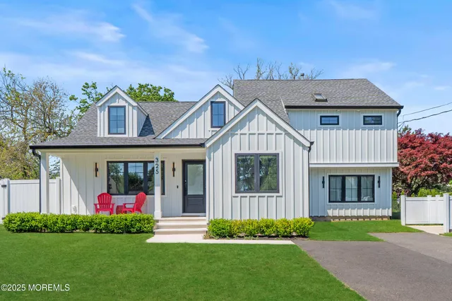 a front view of a house with a yard and potted plants