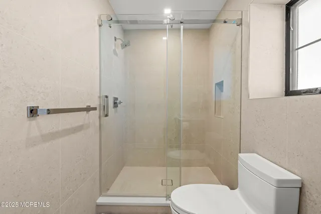 a bathroom with a toilet and a shower