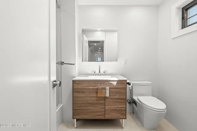 a bathroom with a granite countertop toilet a sink and mirror