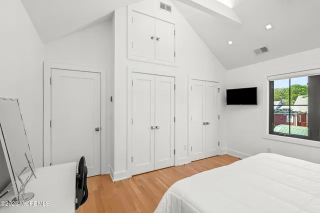 a bedroom with a bed tv and window