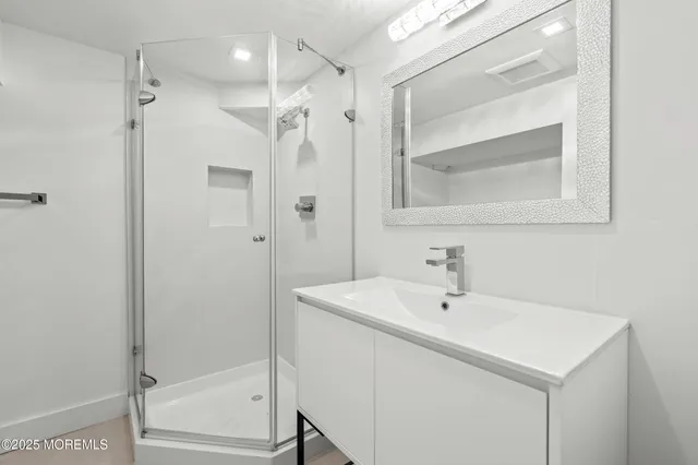 a bathroom with a shower sink and mirror