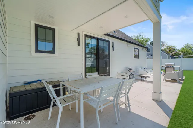 a view of a patio with table and chairs with wooden floor and fence
