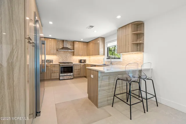 a kitchen with stainless steel appliances granite countertop a stove refrigerator and a sink
