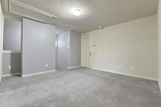 an empty room with windows and chandelier fan