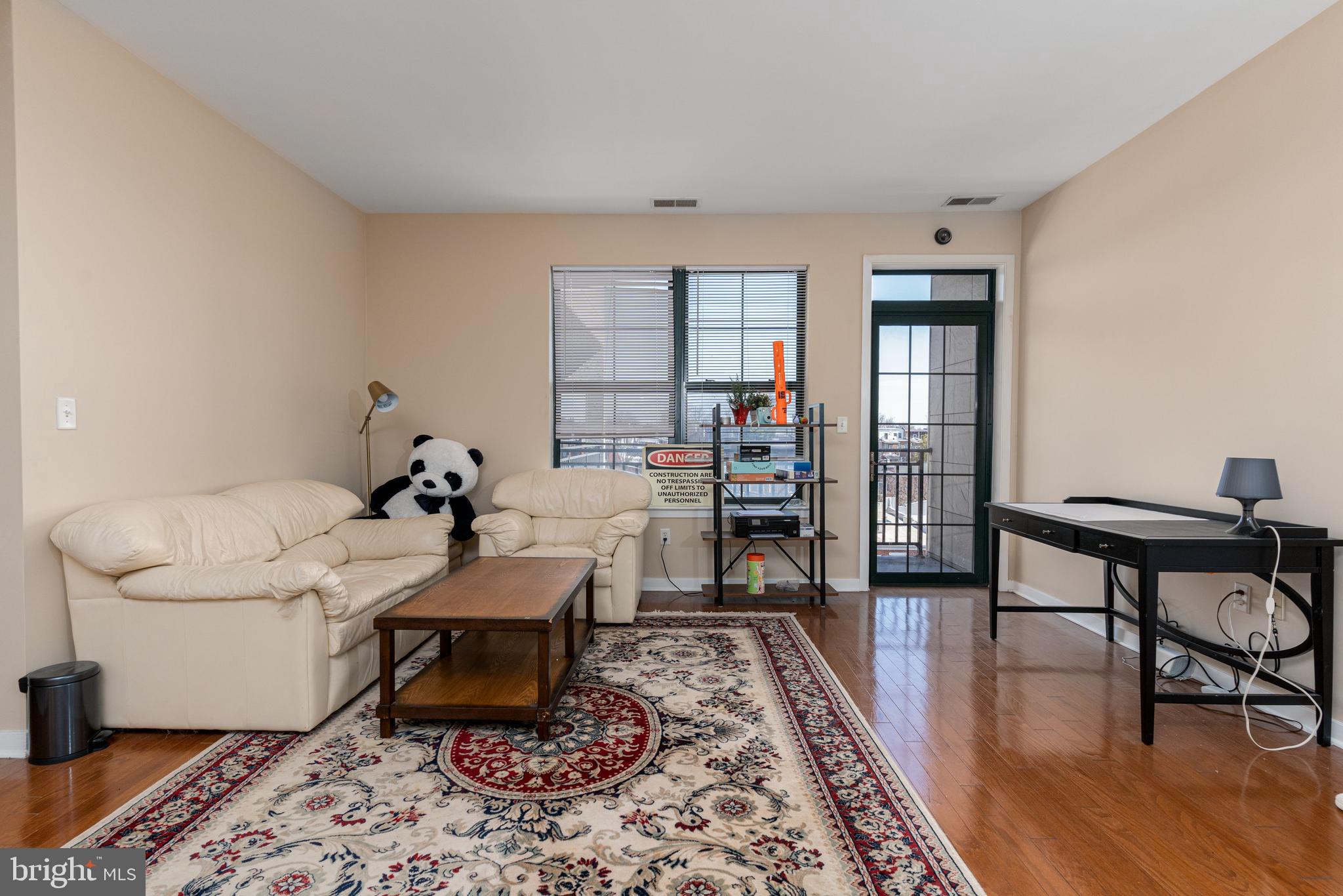 3201 St Paul Street, Unit 422 Baltimore, MD 21218 - Photo 2 of 27 a living room with furniture and a wooden floor