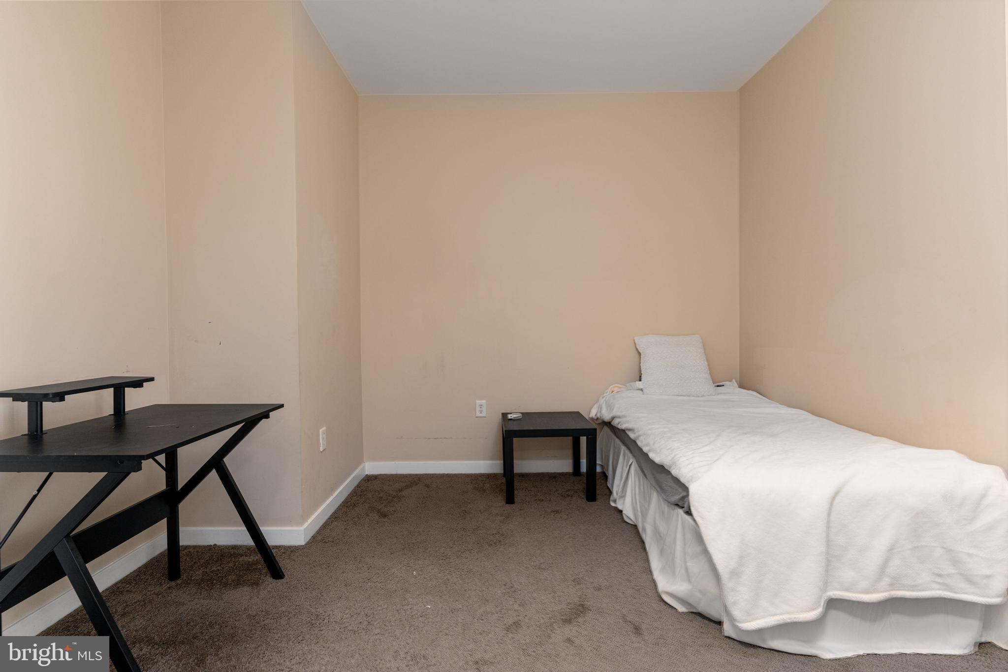 3201 St Paul Street, Unit 422 Baltimore, MD 21218 - Photo 24 of 27 a bedroom with a bed and a table in it