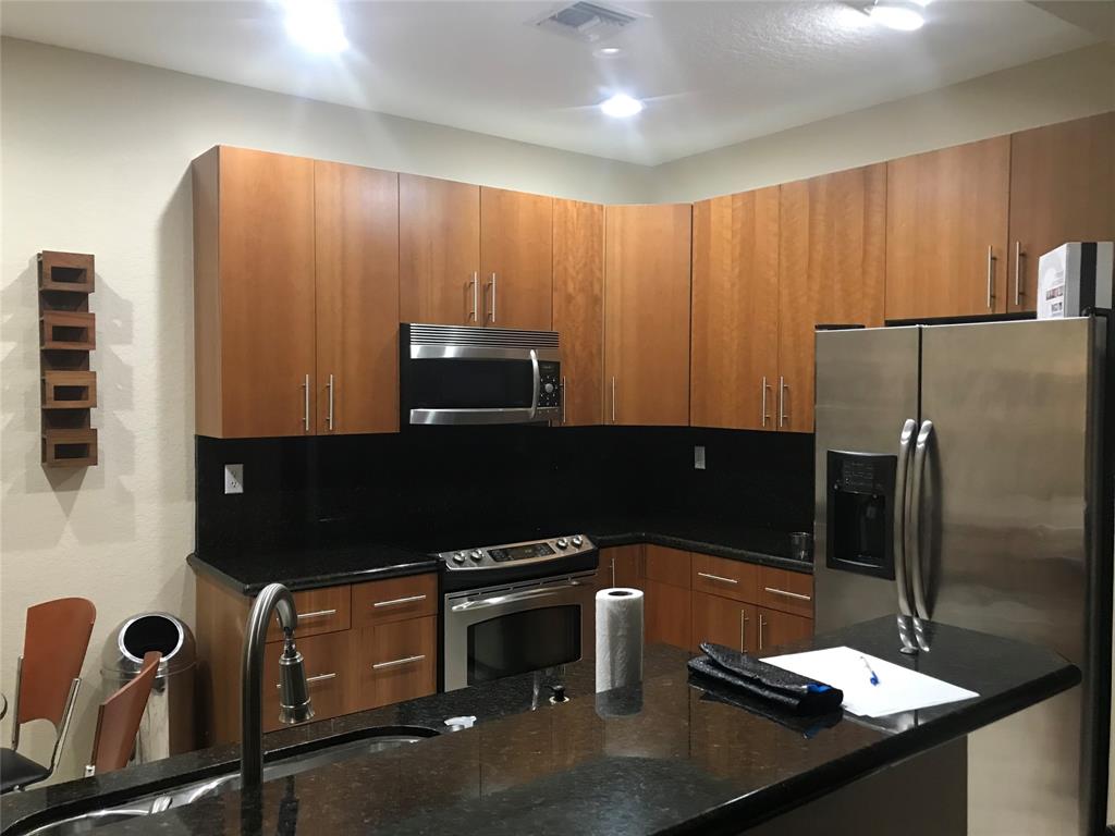 2851 Prospect Road, Unit 106 Fort Lauderdale, FL 33309 - Photo 3 of 6 a kitchen with a sink a refrigerator and a stove top oven
