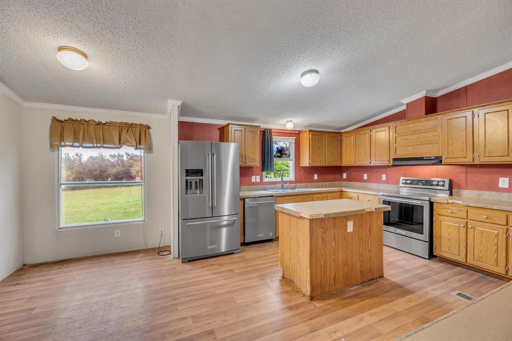 1350 Stephens Road Millsap, TX 76066 - Photo 11 of 29 a kitchen with stainless steel appliances granite countertop a refrigerator a stove top oven a sink and dishwasher with wooden floor