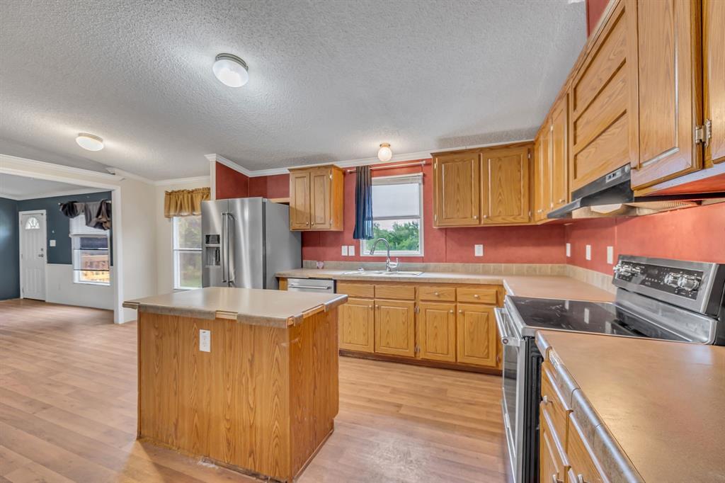 1350 Stephens Road Millsap, TX 76066 - Photo 12 of 29 a kitchen with stainless steel appliances granite countertop a stove a sink and a refrigerator