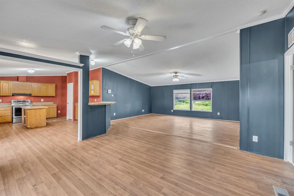 1350 Stephens Road Millsap, TX 76066 - Photo 4 of 29 a view of an empty room with window and wooden floor