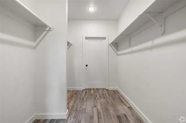 a view of a room with wooden floor and white walls