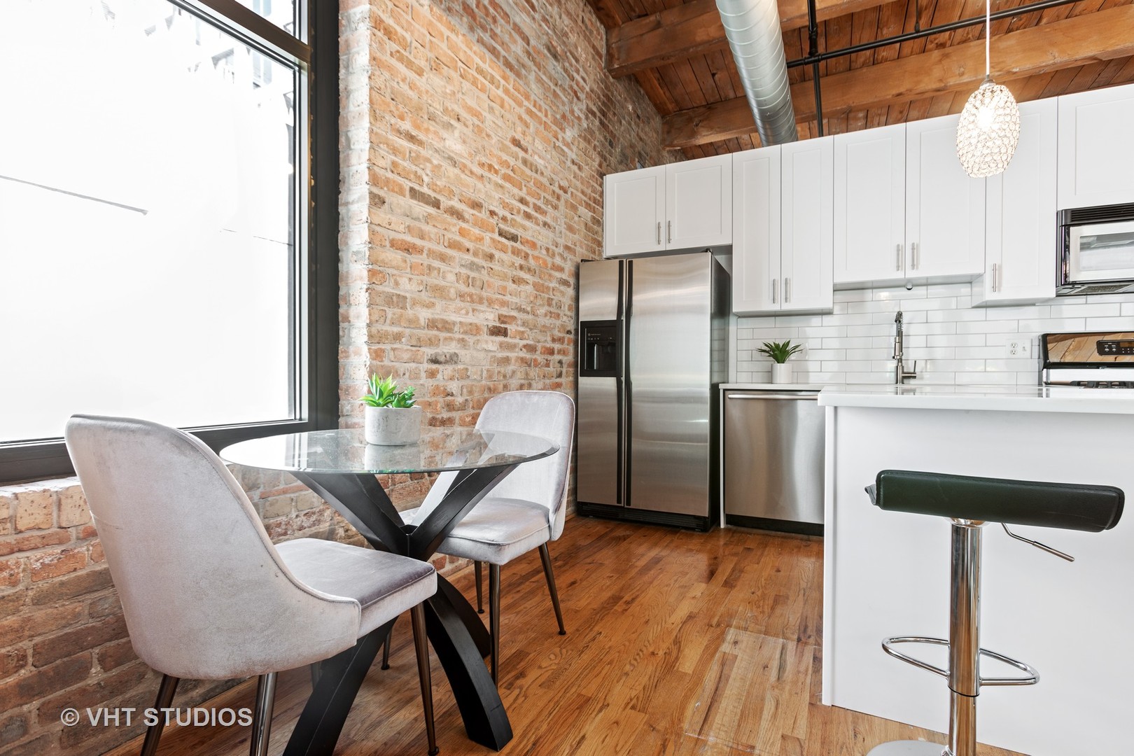 14 North Sangamon Street, Unit 309 Chicago, IL 60607 - Photo 30 of 39 a kitchen with stainless steel appliances kitchen island granite countertop a table chairs and a refrigerator