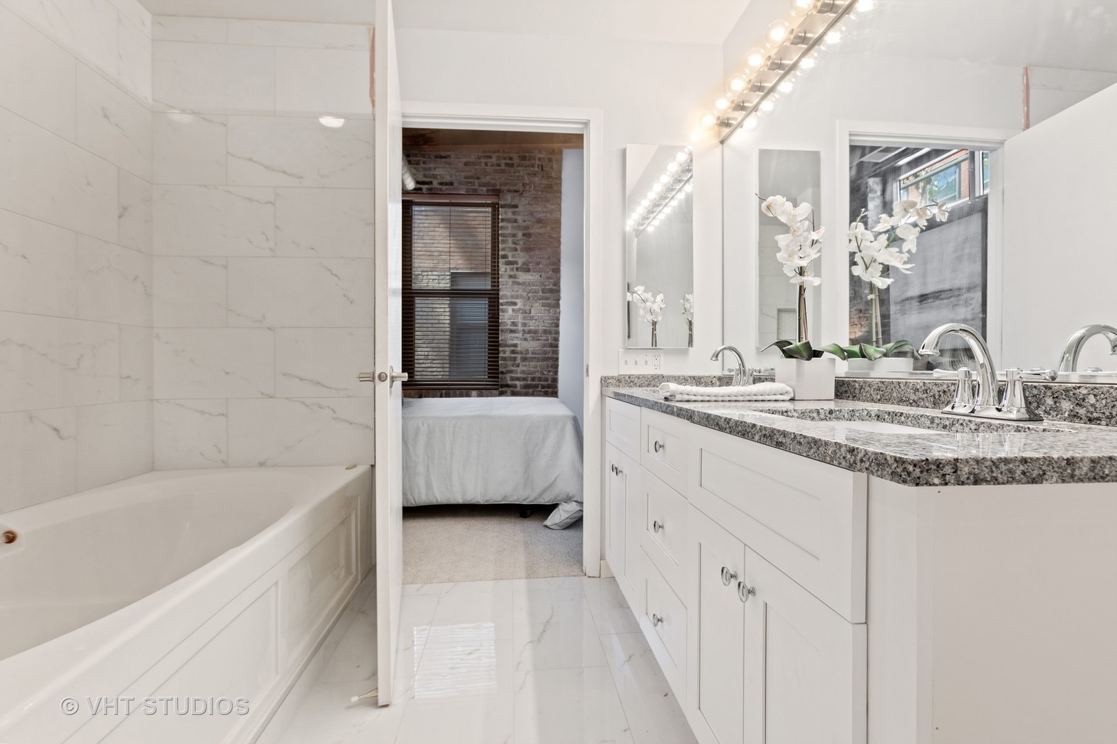 14 North Sangamon Street, Unit 309 Chicago, IL 60607 - Photo 34 of 39 a bathroom with a granite countertop sink a mirror and bathtub