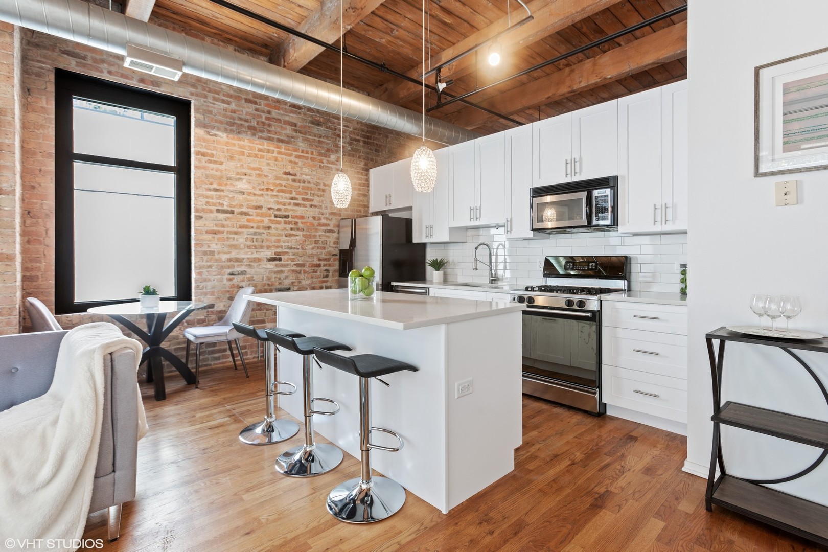 14 North Sangamon Street, Unit 309 Chicago, IL 60607 - Photo 9 of 39 a kitchen with table chairs cabinets and stainless steel appliances