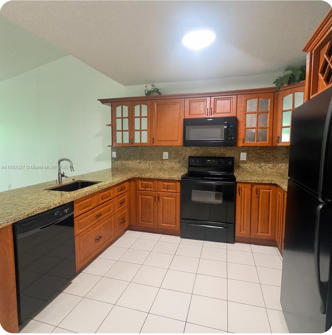 2849 West 71st Street Hialeah, FL 33018 - Photo 11 of 22 a kitchen with stainless steel appliances granite countertop a stove a sink and a refrigerator