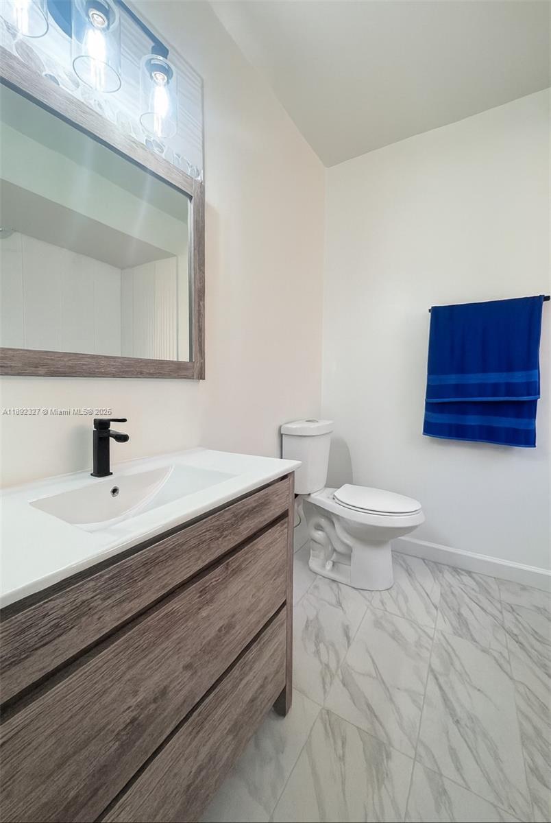 2849 West 71st Street Hialeah, FL 33018 - Photo 16 of 22 a bathroom with a toilet a sink and mirror