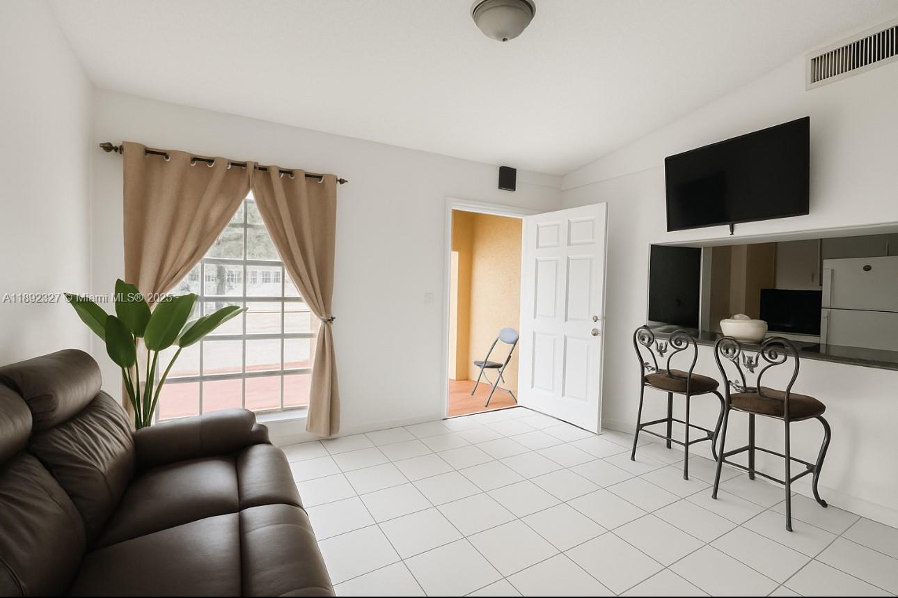 2849 West 71st Street Hialeah, FL 33018 - Photo 4 of 22 a living room with furniture a flat screen tv and a large window