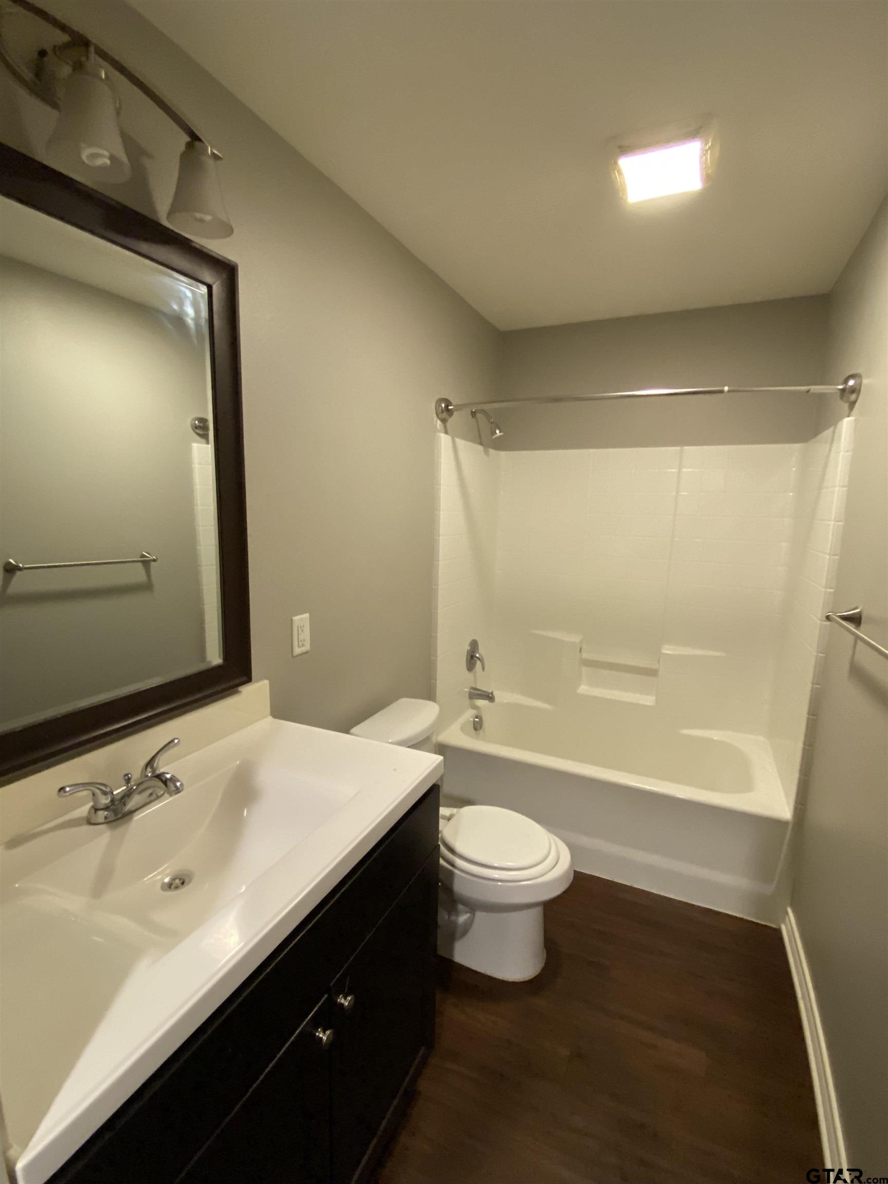 3960 Cottage Drive Tyler, TX 75701 - Photo 5 of 15 a bathroom with a sink a toilet a mirror and bathtub