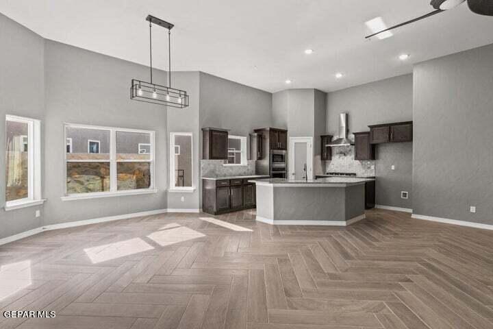 6036 Fall Ridge Street Sunland Park, NM 88008 - Photo 3 of 10 a large kitchen with stainless steel appliances a large counter top a sink and a chandelier