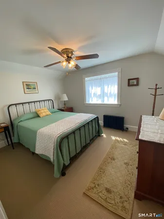 a bedroom with a bed a chandelier and dresser