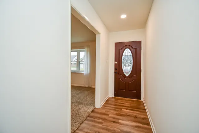 a view of a hallway with wooden floor